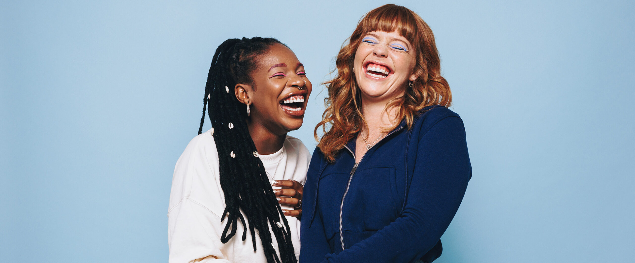 Two women laughing posing for a photo