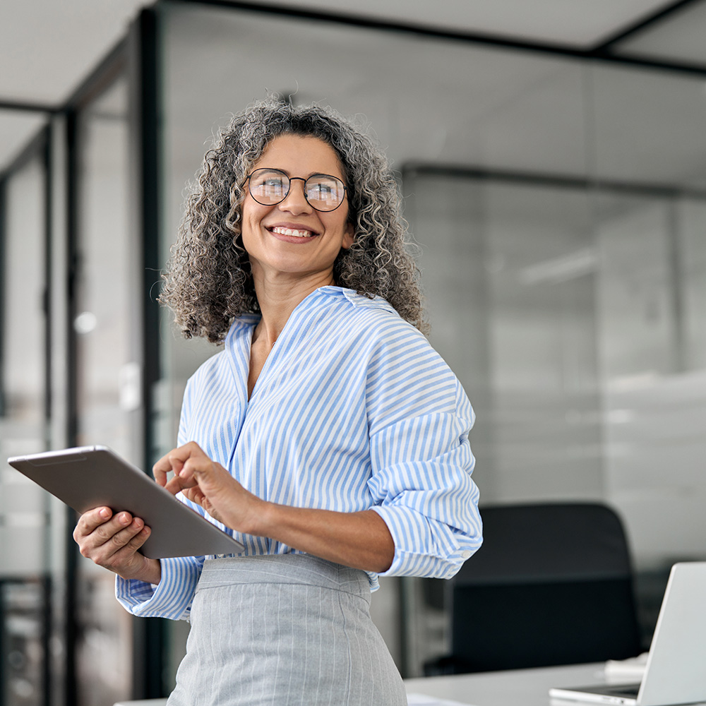 A business woman posing for a photo holding a tablet