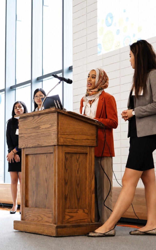 A woman speaking behind a podium at a FuturFund conference