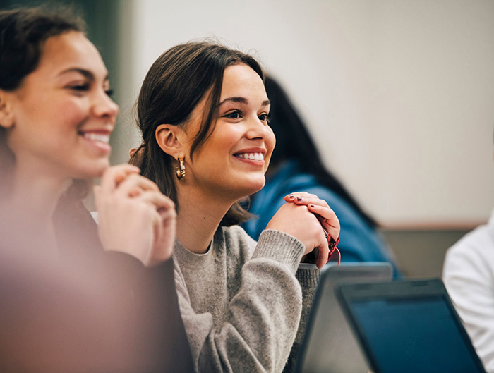 Students sitting in a classroom smiling