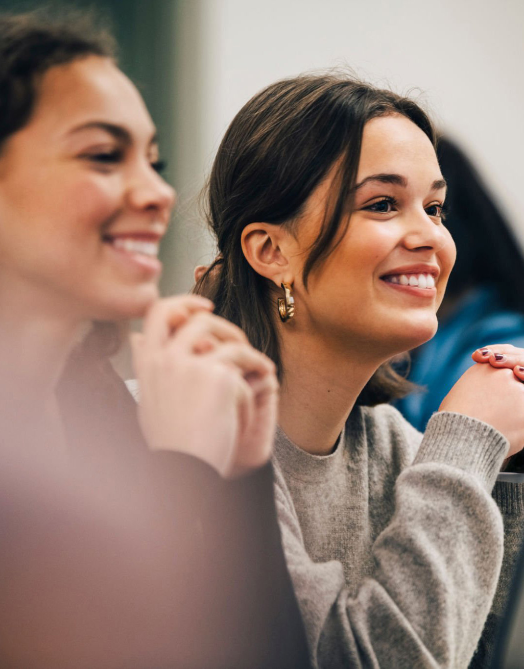 Students sitting in a classroom smiling