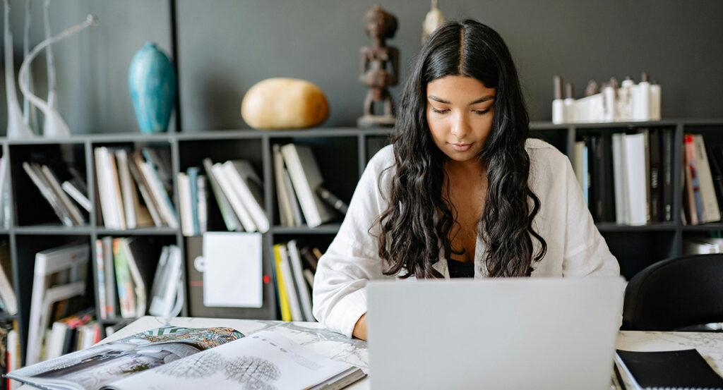 A student sitting at a desk using a laptop